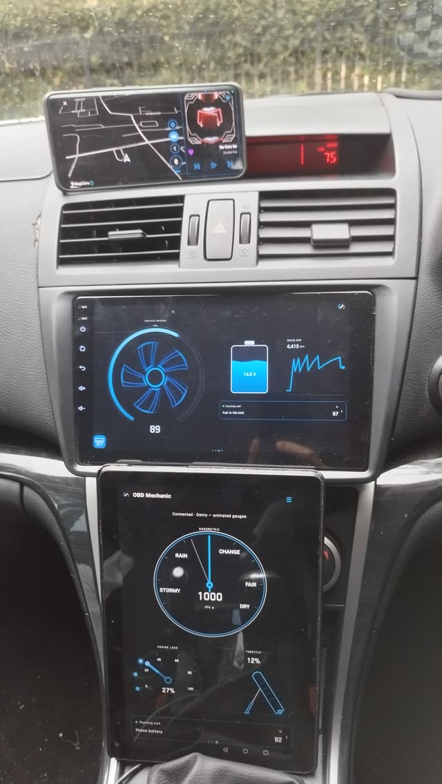 A real car's dash with three screens running the app: a phone on the windscreen, a head unit in the dash and a tablet below